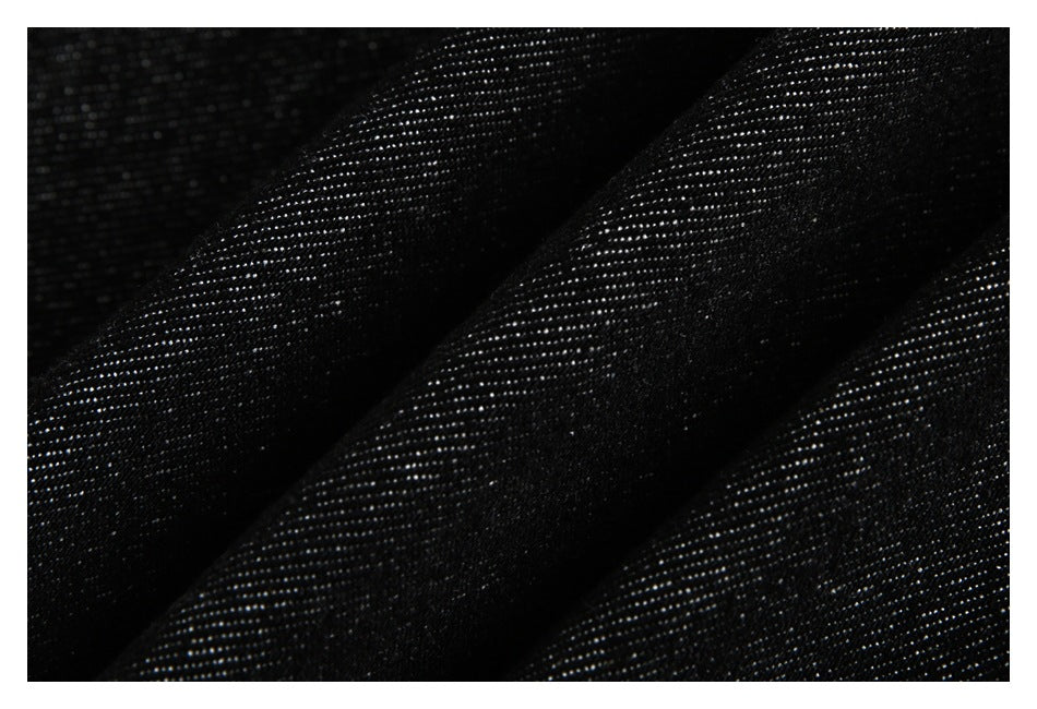 Close-up of black fabric showing a fine, subtly reflective woven texture.