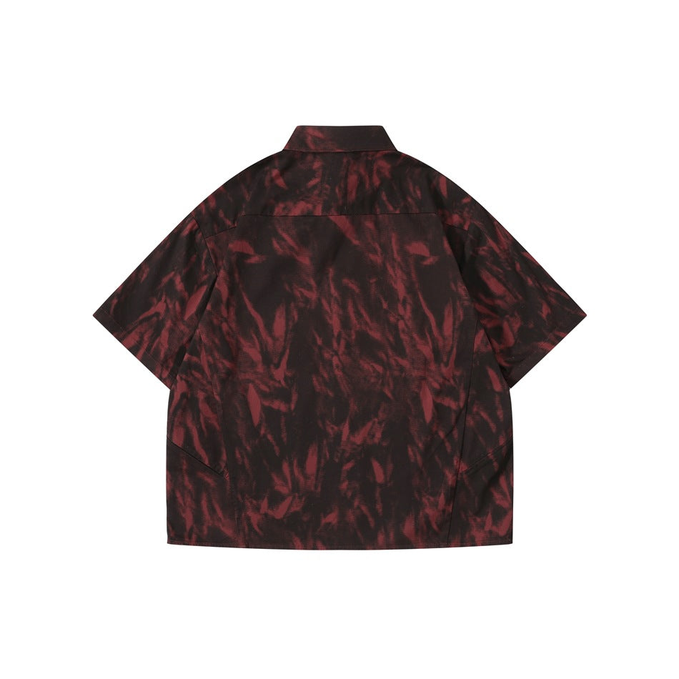 Back view of dark red and black tie-dye style short-sleeve shirt with yoke seam, flat lay