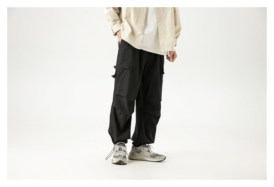 Model wearing loose black cargo pants, shown at an angle that highlights the large side cargo pocket.