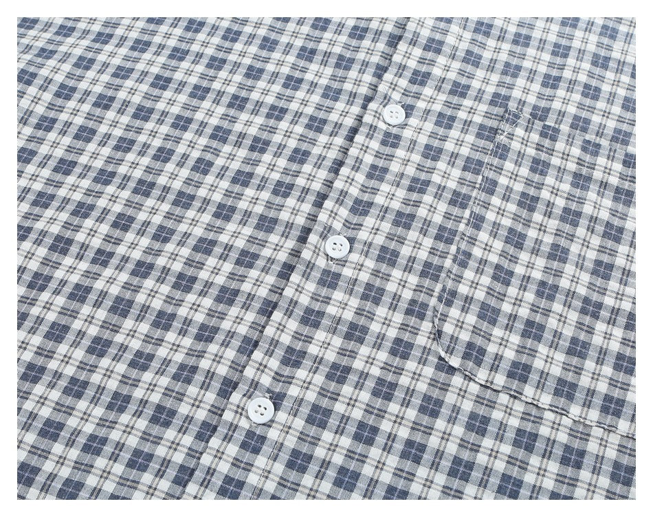 Angled close-up of the blue-gray plaid shirt's button placket and chest pocket.