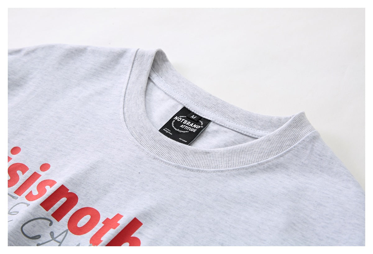 Close-up of a light gray T-shirt collar and neck label, with part of the red chest print visible.