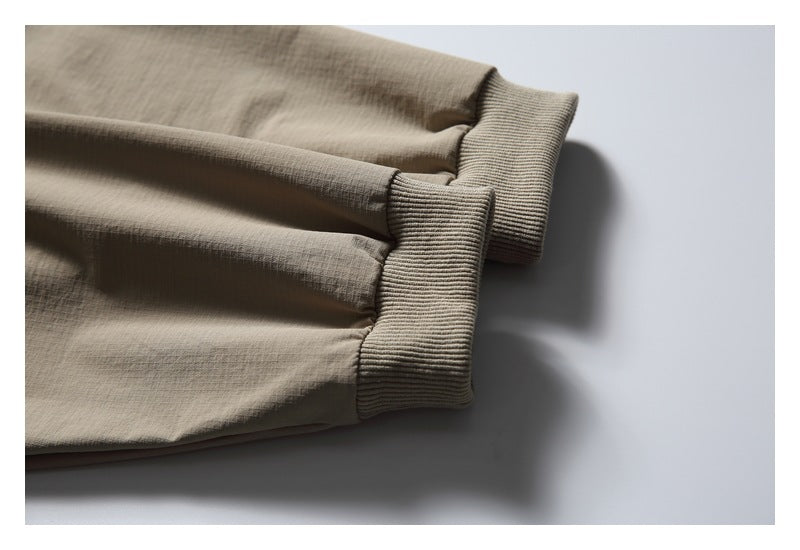 Close-up of two taupe garment cuffs with ribbed knit bands.