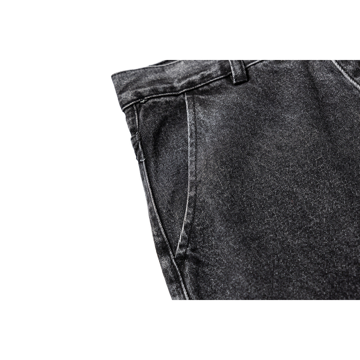 Close-up of charcoal-black washed denim waistband, belt loop, and curved side pocket seam.