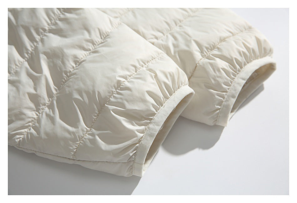 Close-up of an ivory quilted jacket sleeve cuff with soft binding.