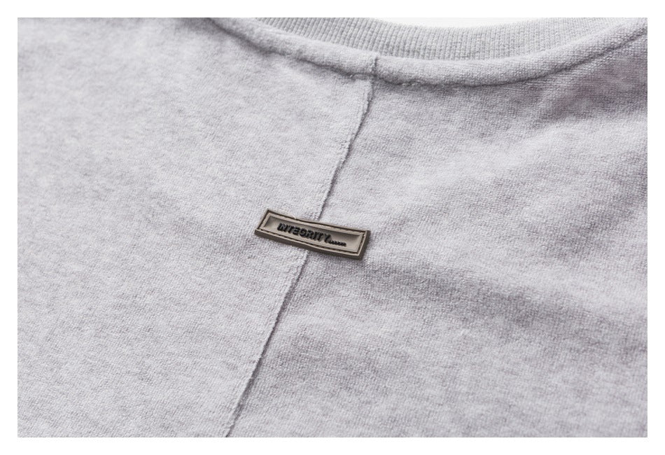 Close-up of a heather-gray neckline and center seam with a small rectangular garment label.
