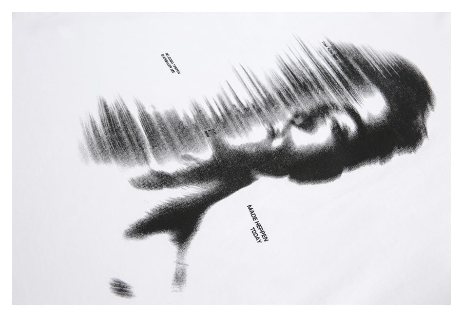 Close-up of an abstract black face graphic and small English lettering printed on a white T-shirt.