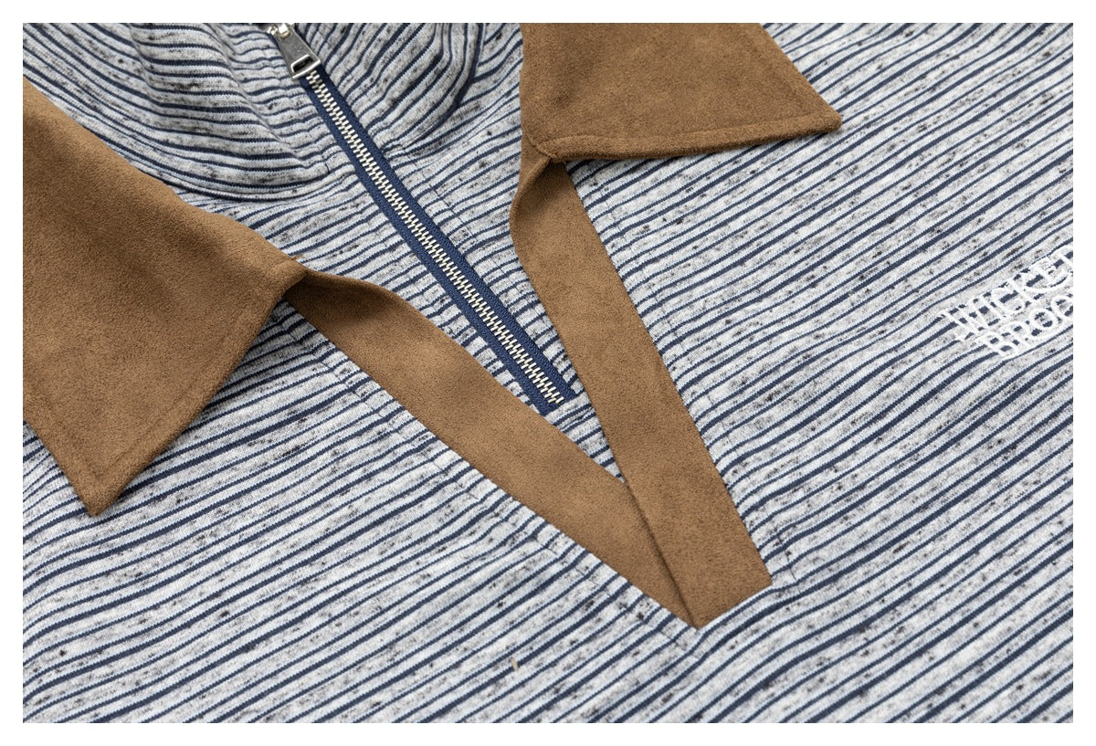 Close-up of the top’s front zipper and tan lapel trim against gray and navy striped fabric.