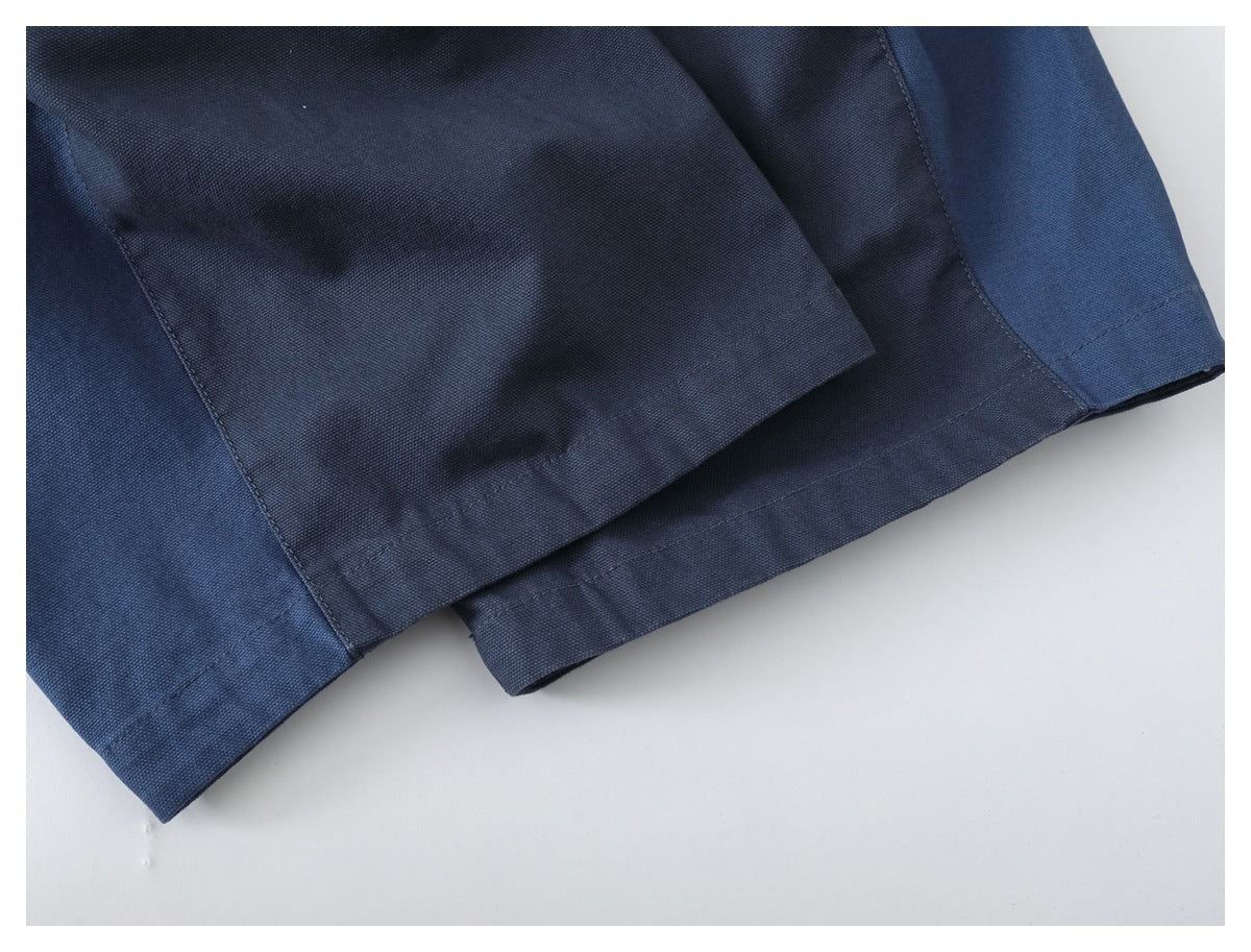 Close-up of navy garment hems with stitched panel seams and a textured weave.