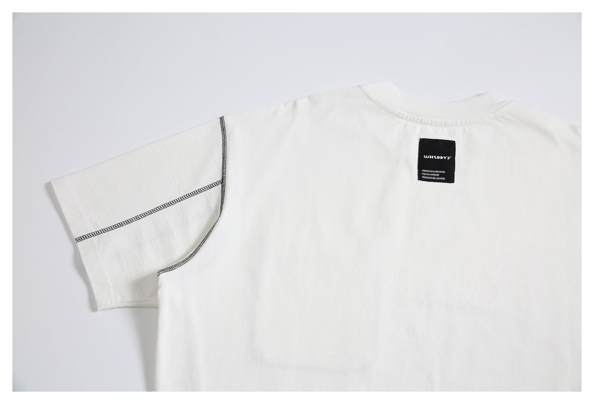 Upper back of an off-white T-shirt with black contrast stitching and a small black neck label.