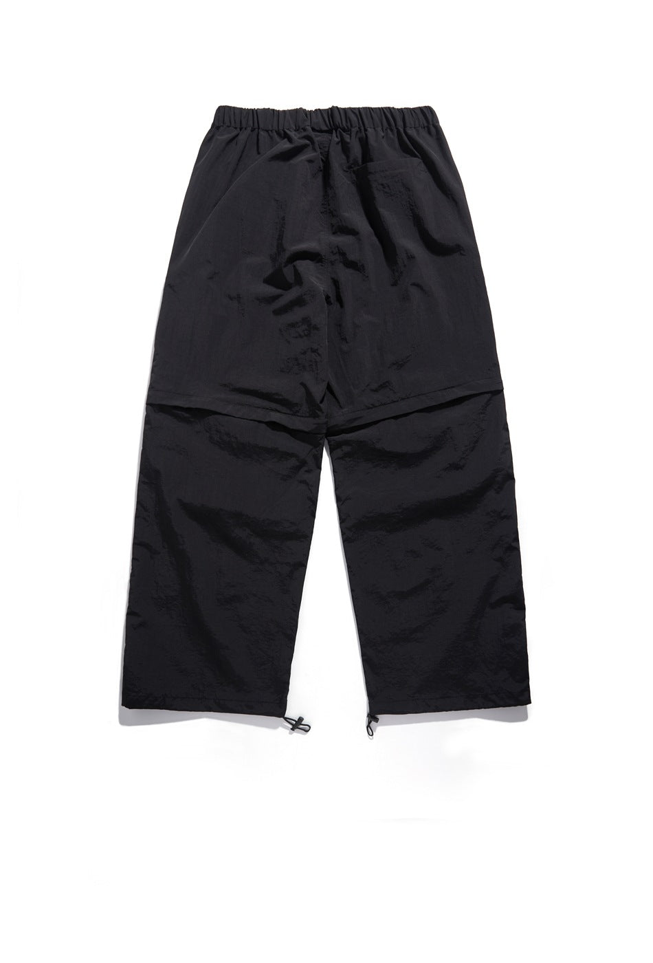 Back view of black wide-leg pants with an elastic waistband, a rear pocket, panel seams and adjustable hems.
