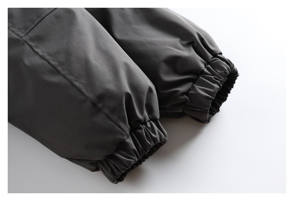 Close-up of a black jacket sleeve with a stitched seam and gathered elastic cuff.
