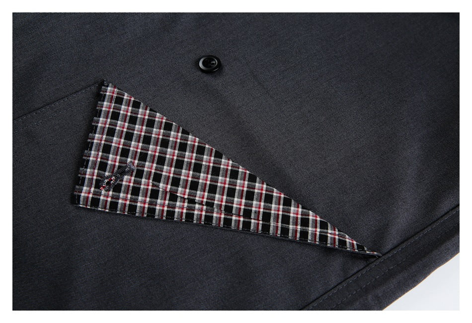 Close-up of charcoal trousers showing a pocket lined with a red, white, and black plaid fabric.