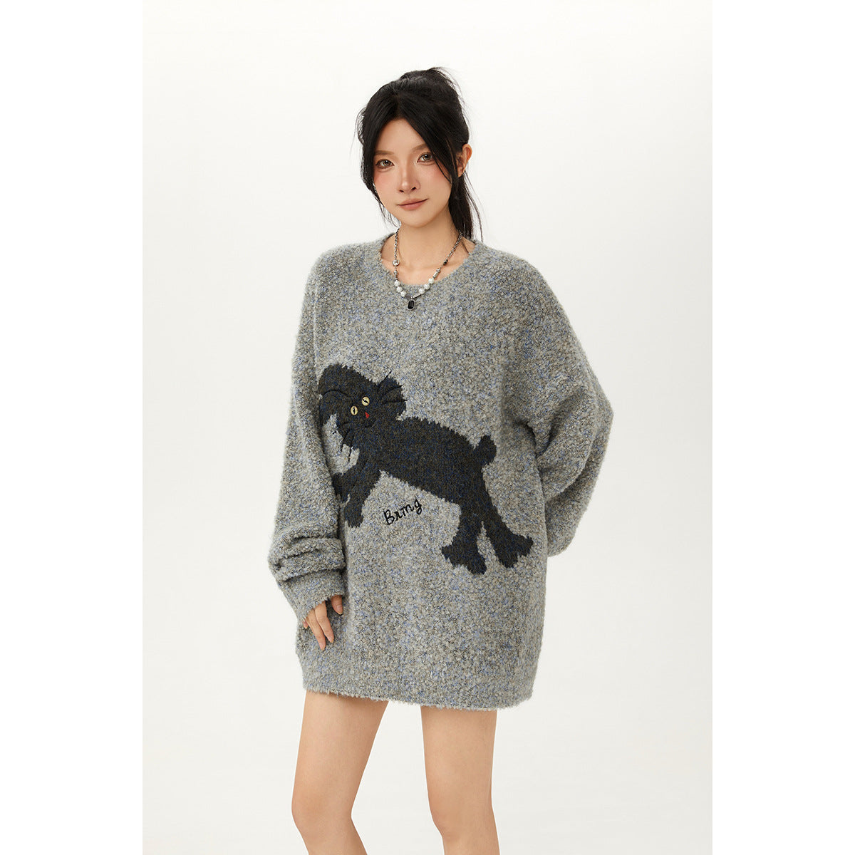 Model wearing an oversized gray-blue sweater with a large black cat graphic on the front.