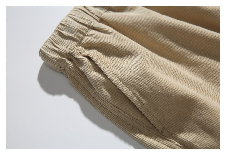 Close-up of gathered tan trouser fabric and a stitched seam.
