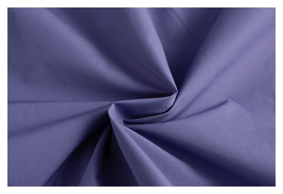 Close-up of purple fabric gathered into folds, showing its fine textured surface.