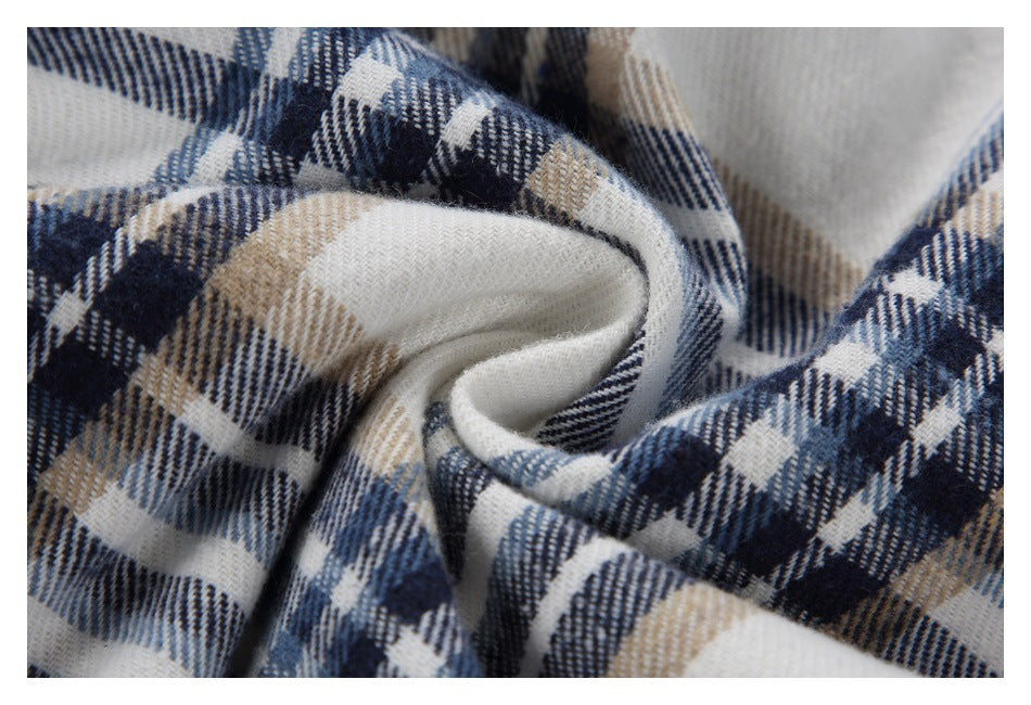 Macro view of gathered white plaid fabric in navy, blue-gray, and tan.