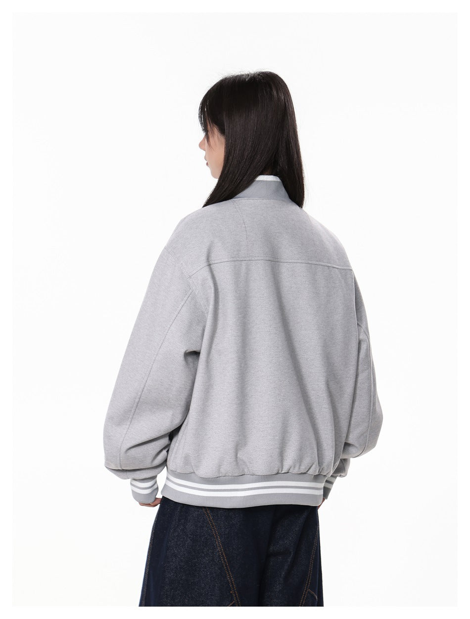 Angled rear view of a model wearing a light gray bomber jacket with striped ribbed trim.