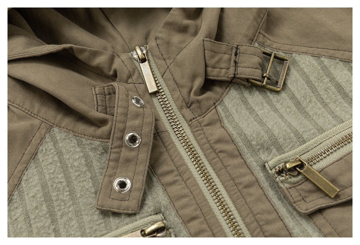 Close-up of a taupe jacket with a central metal zipper, snap-tab closure, buckle strap and striped panels.