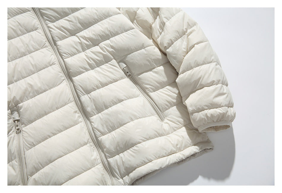 Cropped view of an ivory quilted jacket front, showing the center zipper, zip pockets, and sleeve.