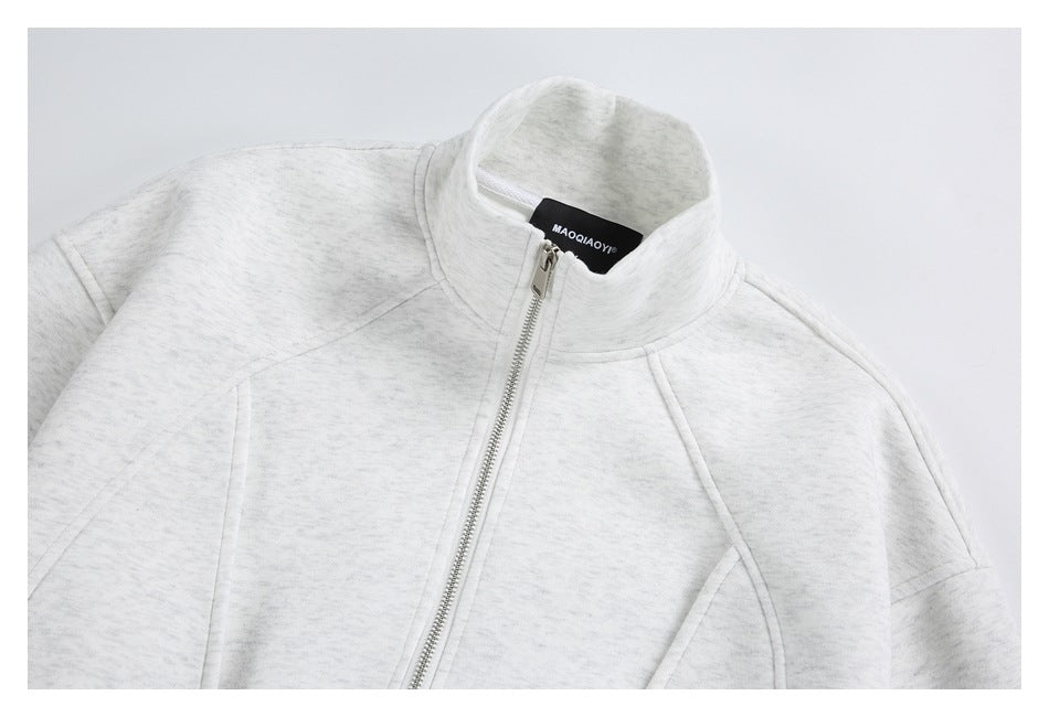 Close-up of a light gray marled jacket with a stand collar, silver front zipper, and black neck label.