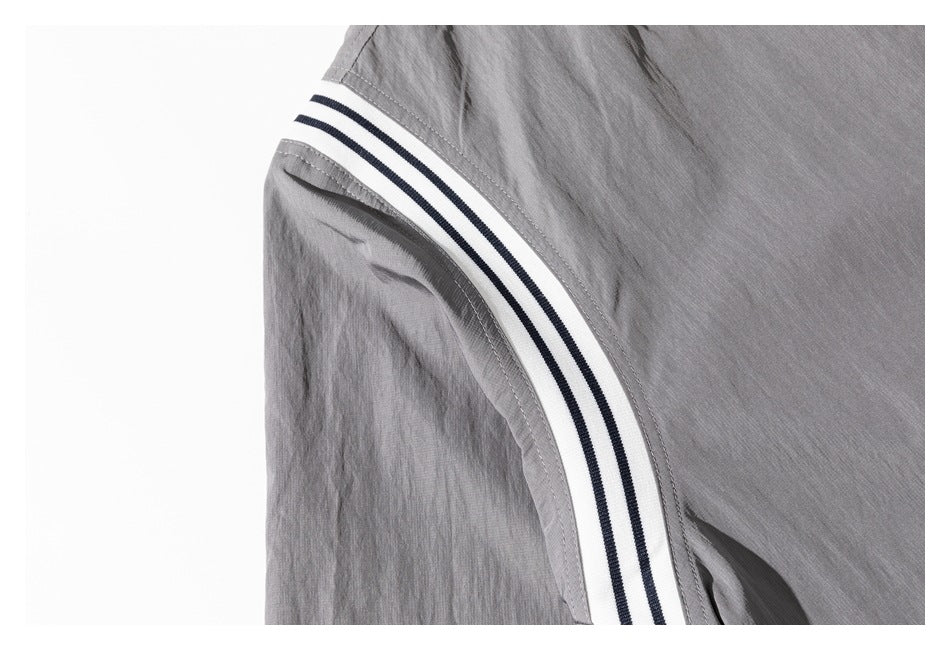 Close-up of the jacket's curved white shoulder trim with two dark stripes and gray stitching.