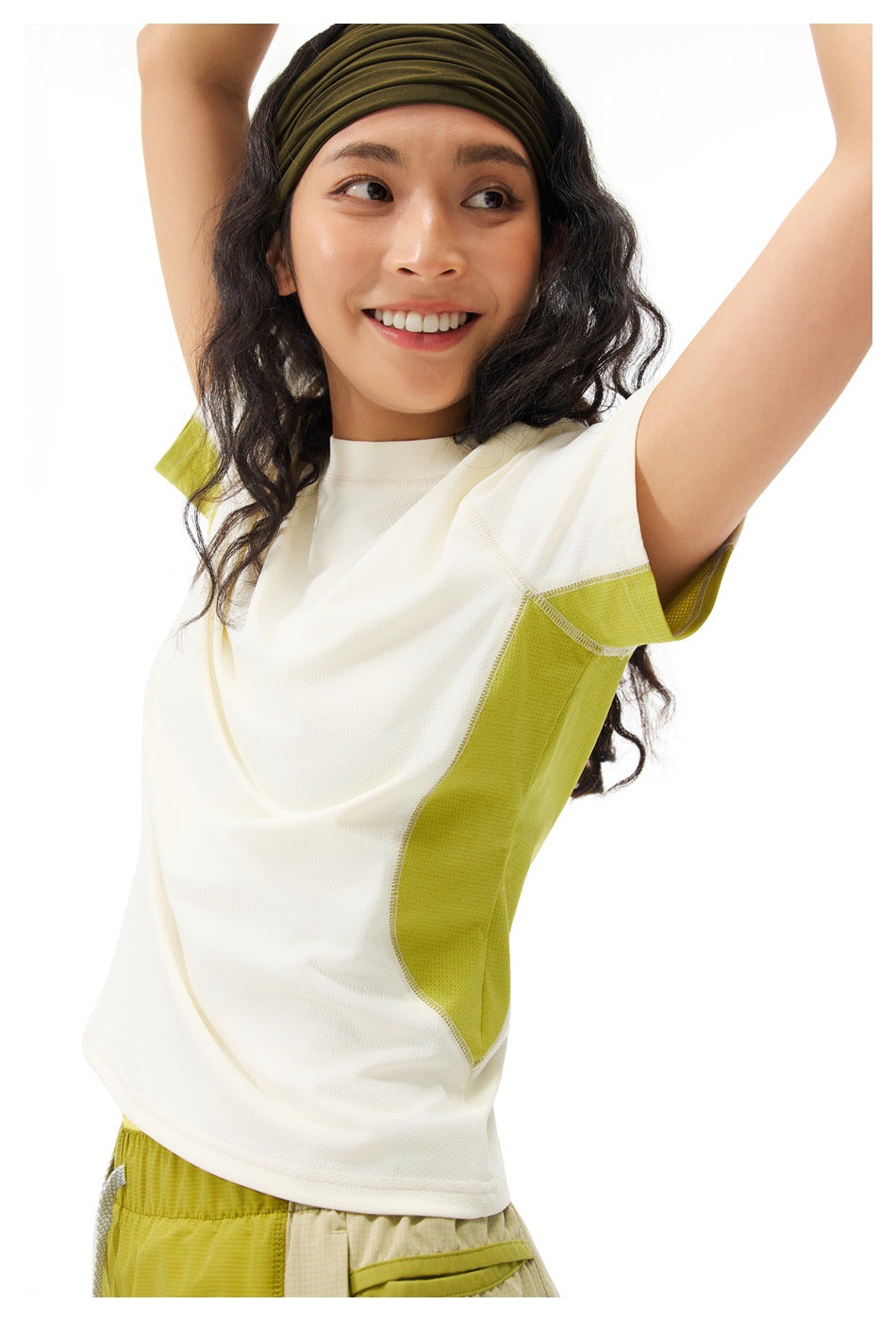 Model wearing an ivory short-sleeve shirt with lime side panels and lime shorts, arms raised.