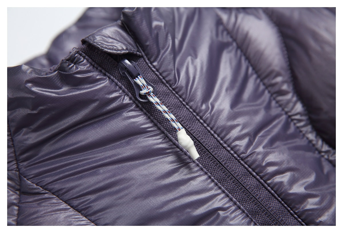 Extreme close-up of a zipper and cord pull on the jacket’s shiny quilted shell.