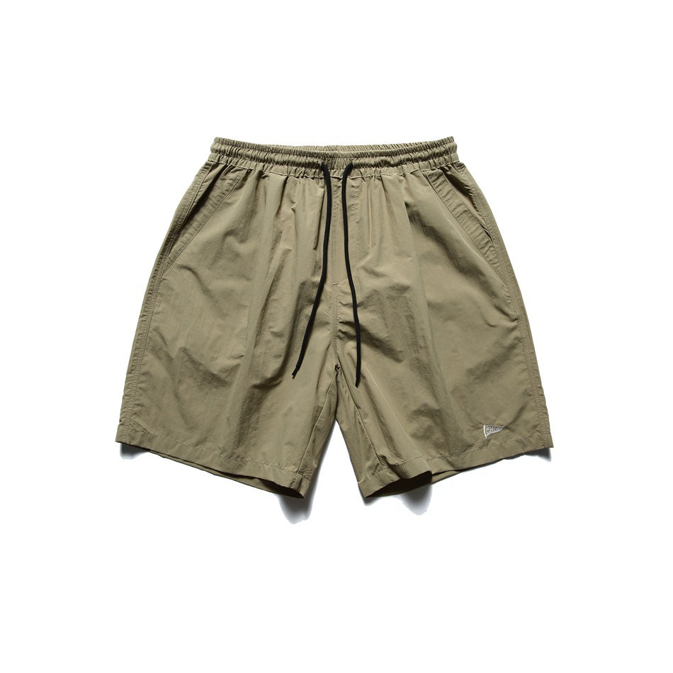 Khaki drawstring shorts with elastic waist and side pockets, flat lay front view