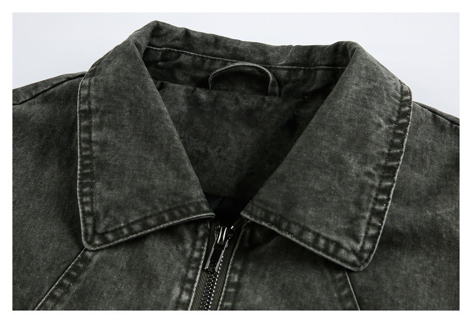 Close-up of a dark charcoal washed jacket's pointed collar and front zipper.