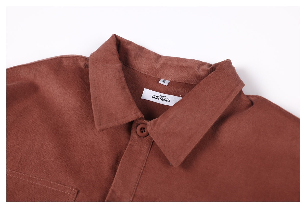 Close-up of the rust-brown shirt's front collar, top button, and sewn neck labels.