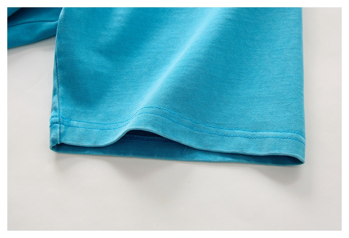 Close-up of the double-stitched bottom hem on a turquoise T-shirt.
