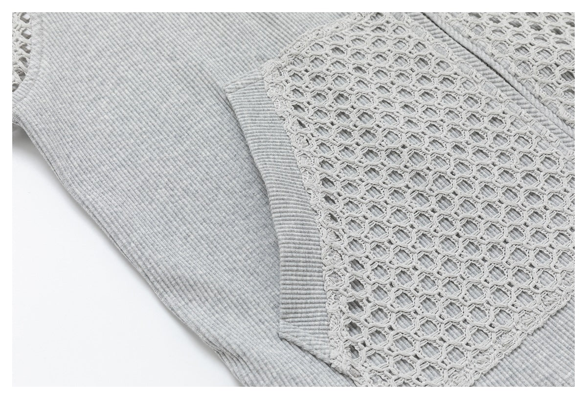 Close-up of a light gray ribbed sleeve beside an openwork crochet panel on the garment.