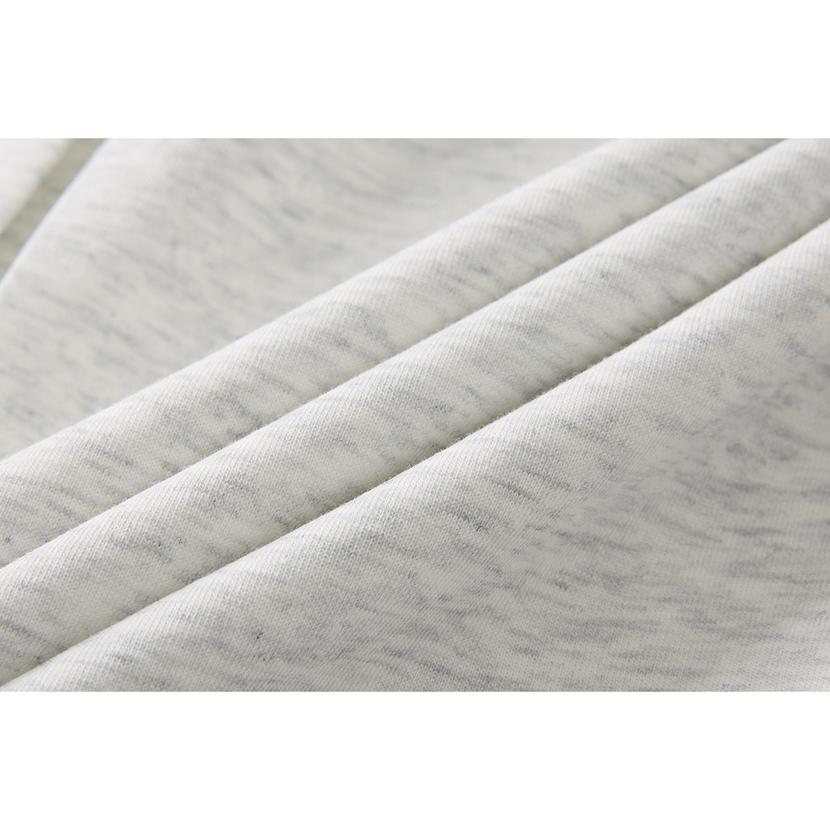 Macro view of the light gray heather polo shirt fabric folded into soft diagonal ridges.