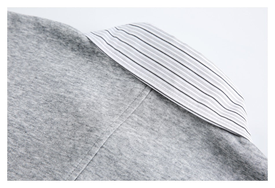 Close-up of a gray knit garment with a white insert featuring thin dark stripes.