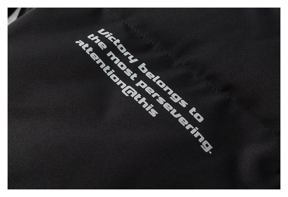Close-up of white English text printed on black jacket fabric.