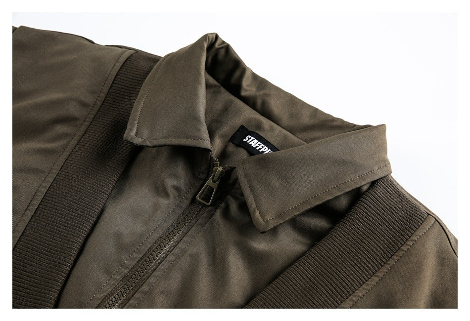 Close-up of the jacket's collar, front zipper and ribbed trim, with a black neck label.