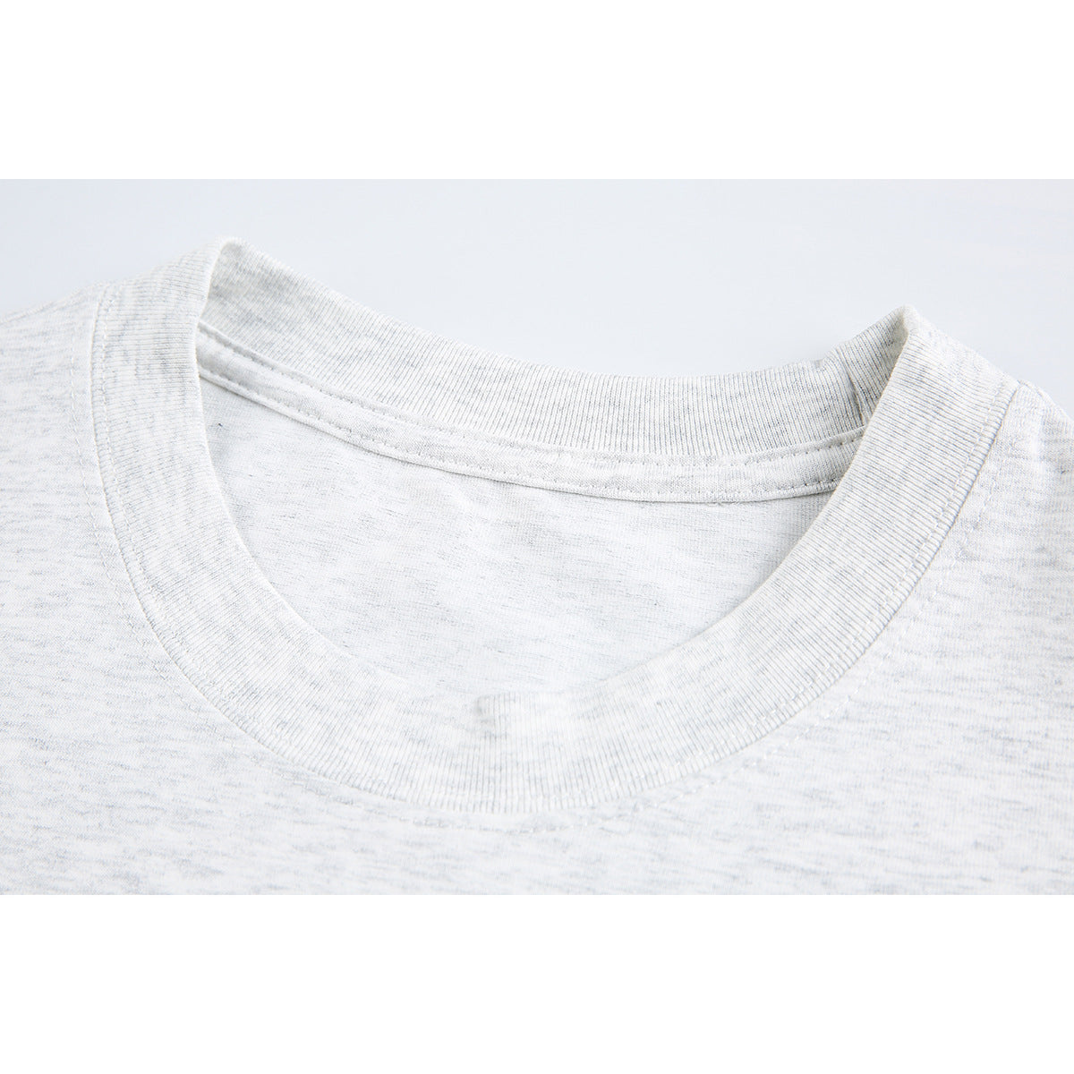 Close-up of a light gray marled T-shirt's ribbed crew neck and collar stitching.
