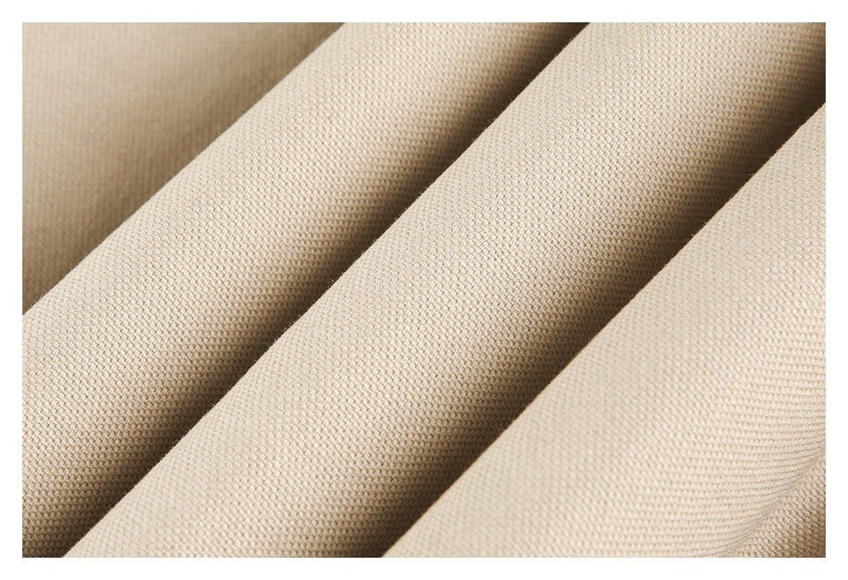 Macro view of the beige coat's textured woven fabric folded into soft ridges.