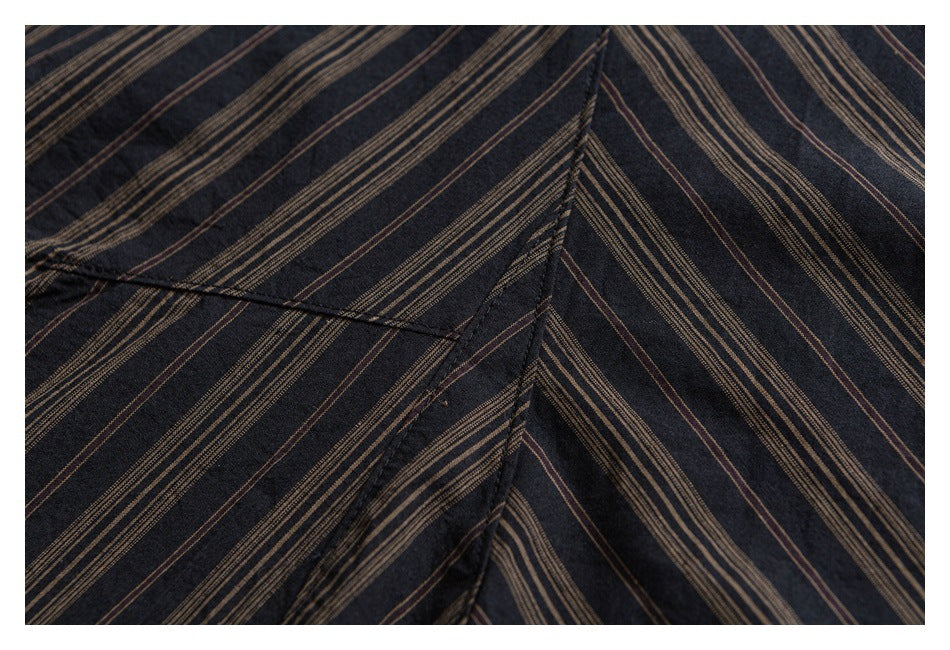 Close-up of striped shirt panels meeting at a stitched seam, showing the brown-on-dark pattern.