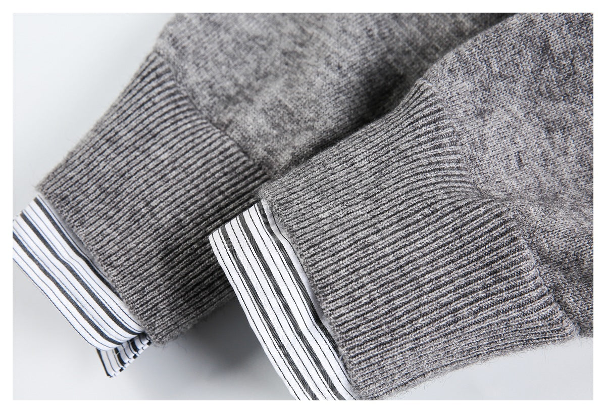 Close-up of gray ribbed cuffs with black-and-white striped shirt cuffs showing underneath.
