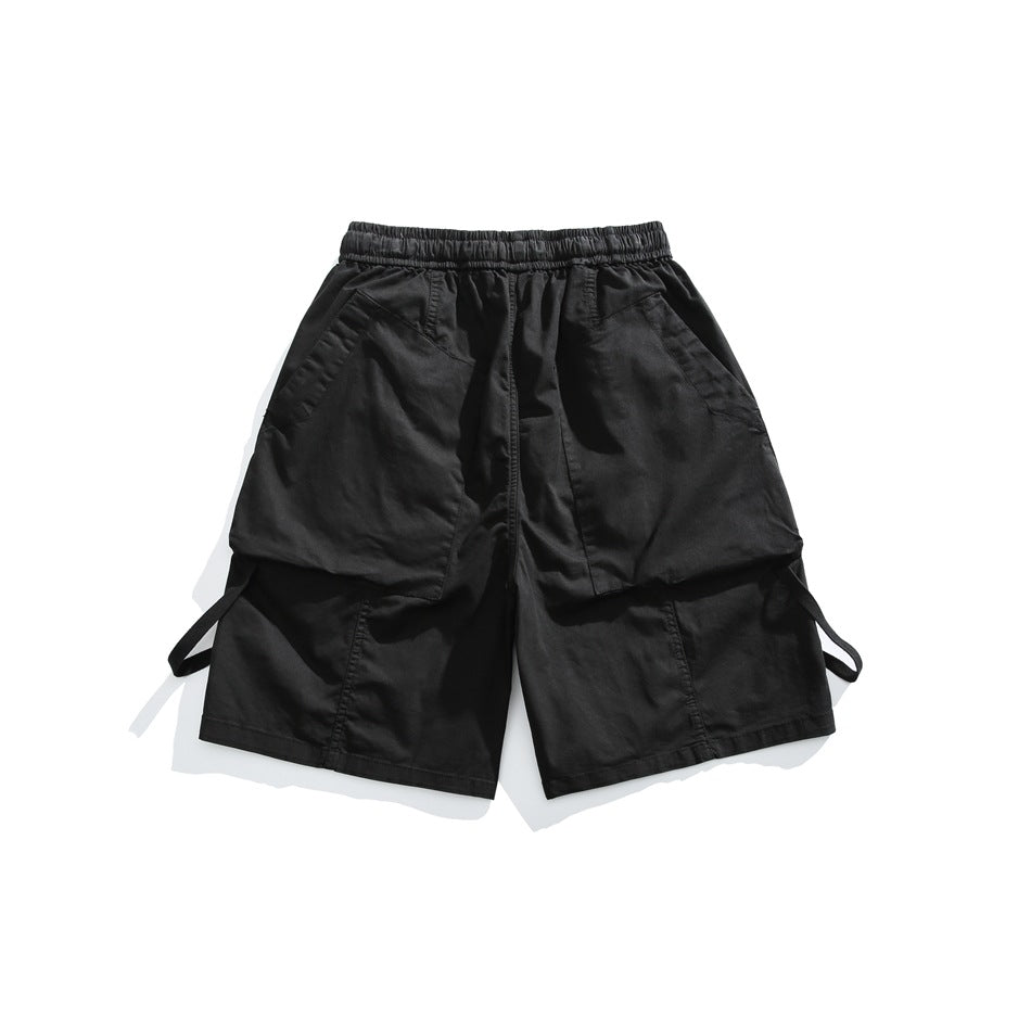 Black cargo shorts laid flat, showing an elastic waistband, front pockets, and wide leg panels.