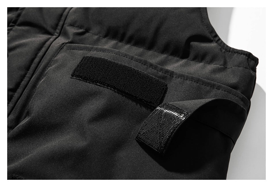 Close-up of a black garment with a hook-and-loop fastening tab and matching rectangular patch.