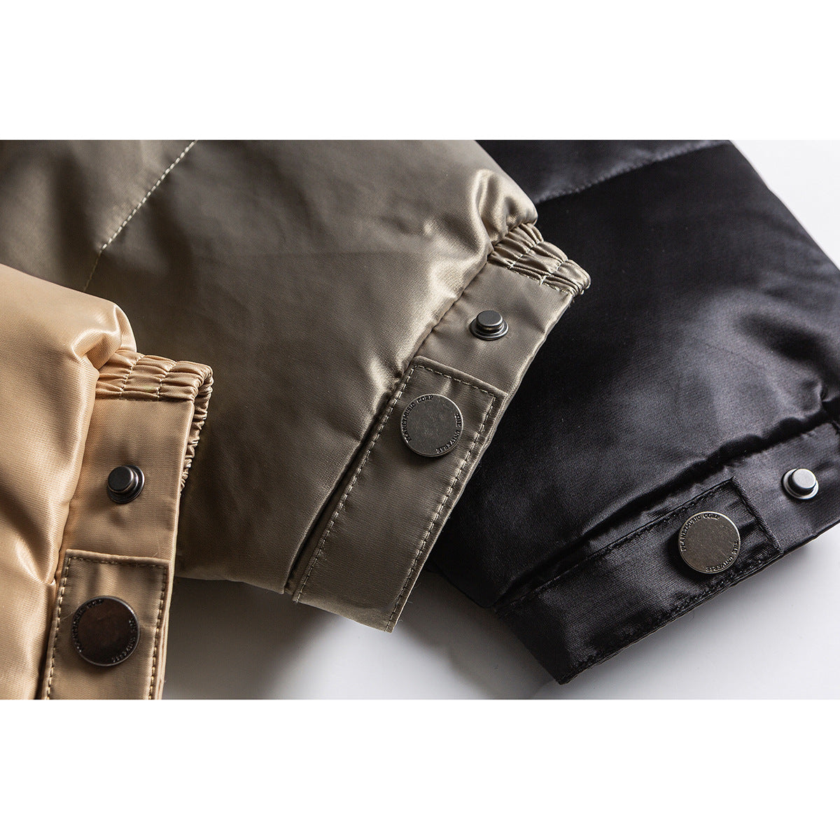Close-up of snap-button cuffs on taupe, tan, and black jackets.