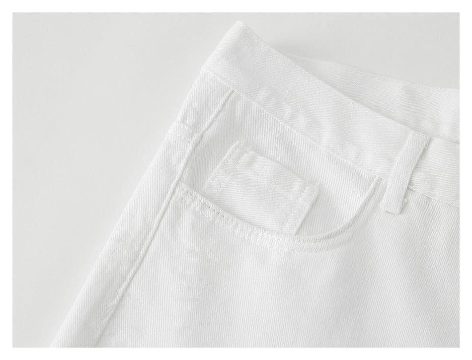 Close-up of white trousers showing a small front pocket, waistband, and belt loop.
