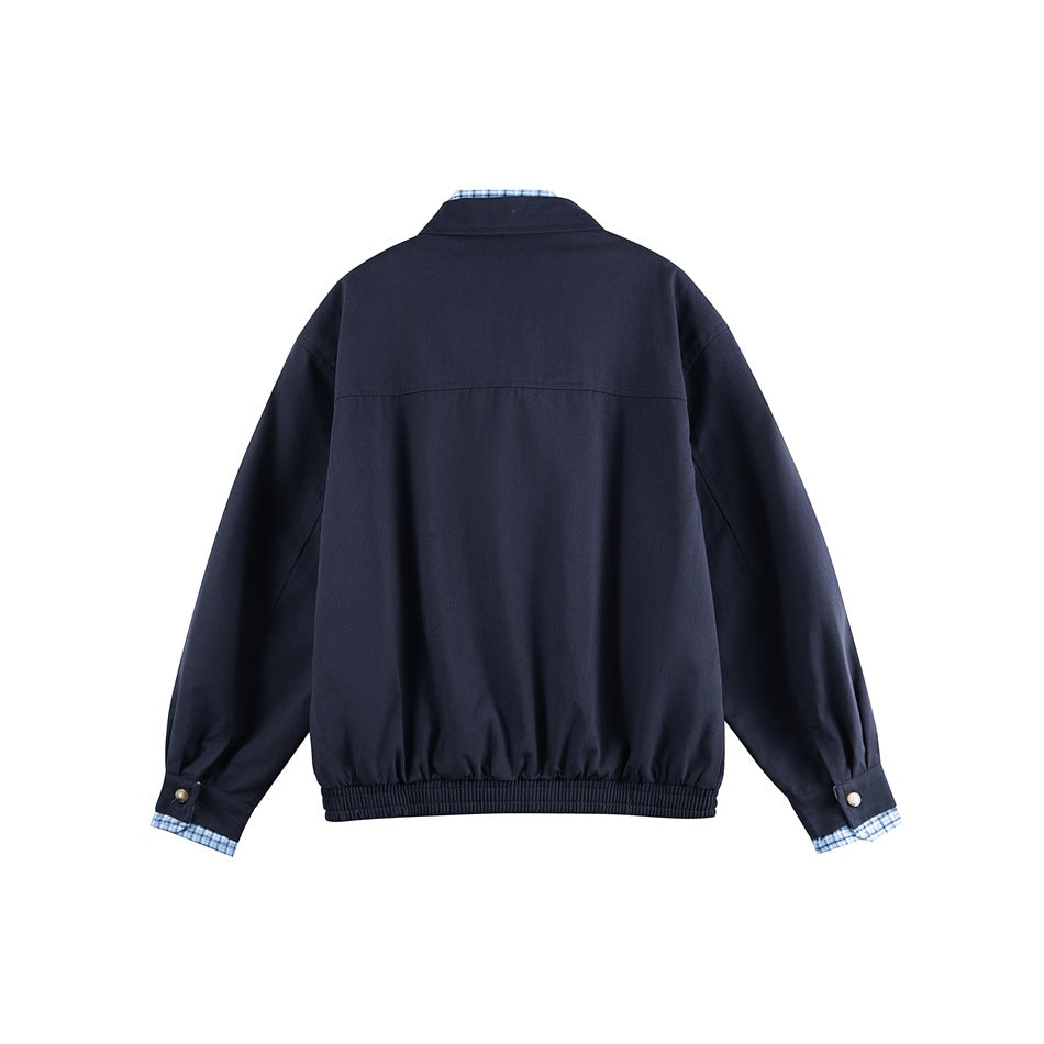 Back view of navy blue jacket with yoke seam, ribbed hem and button cuff tabs with blue check cuff trim