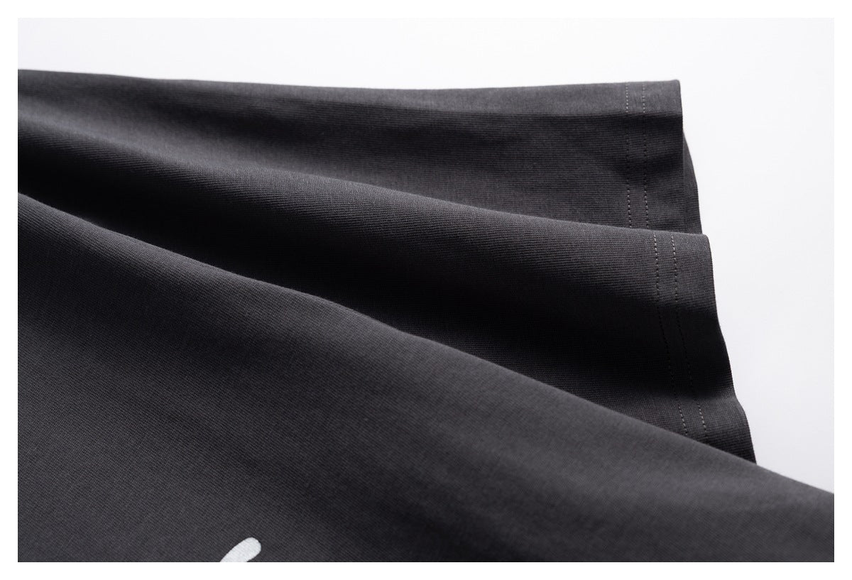 Close-up of the charcoal T-shirt's fabric draped to show its stitched hem.