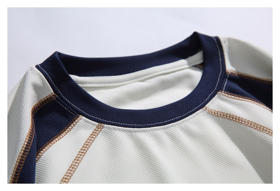 Close-up of the navy crew neckline and contrasting overlock seams on the ivory shirt.