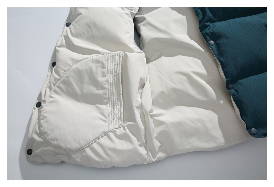 Inside view of a white garment with a large stitched pocket, dark snaps, and a dark teal quilted edge.