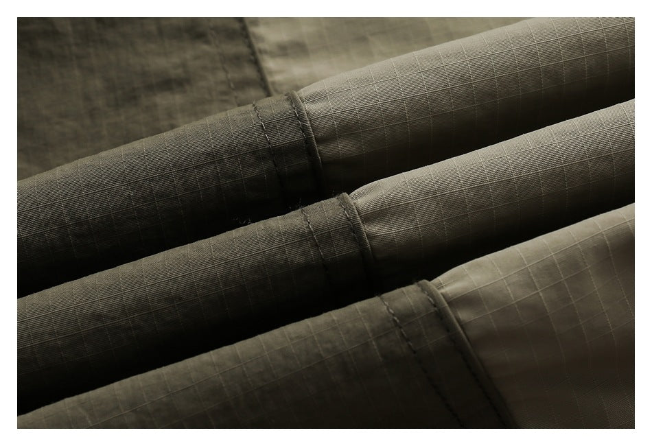 Close-up of olive fabric sections showing a fine square grid texture and stitched bands.