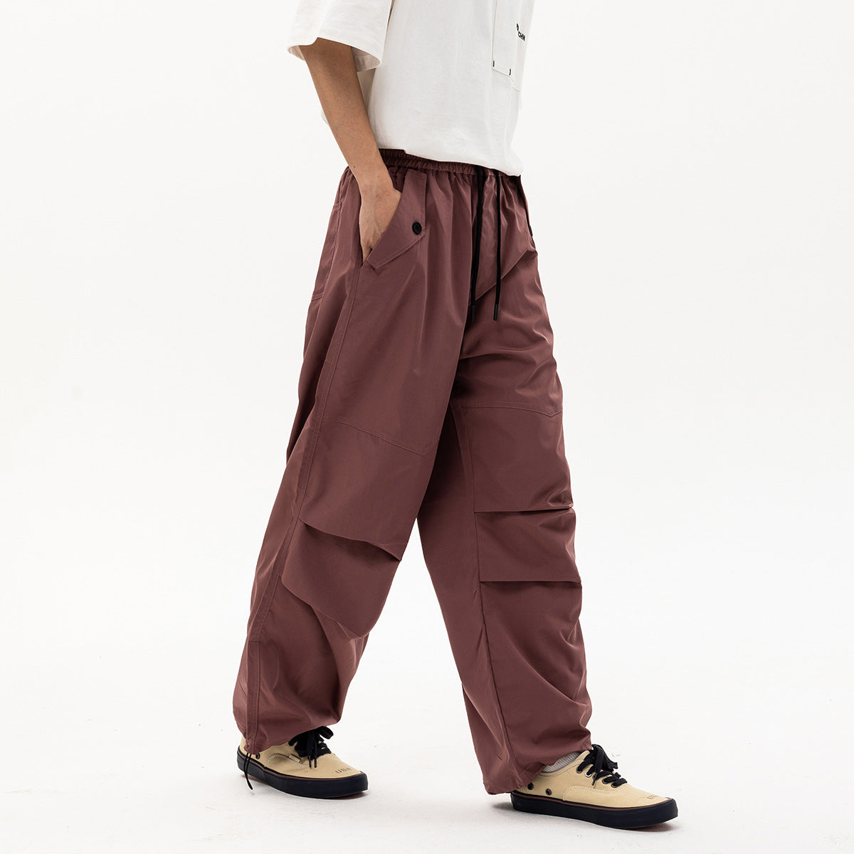 Front-side view of a model wearing loose mauve cargo pants with an elastic drawstring waist and layered leg pockets.